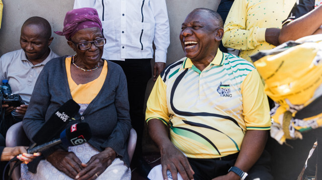 Une supporteuse âgé du président du Congrès national africain (ANC) et du président sud-africain Cyril Ramaphosa (R) partagant un moment de lumière lors d'une campagne électorale à Kwaximba le 20 avril 2024 avant les élections présidentielles sud-africaines prévues pour le 29 mai 2024.