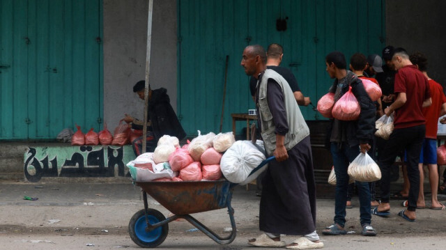 Un homme utilise une brouette pour transporter des sacs de pain à Rafah, dans le sud de la bande de Gaza, le 26 avril 2024.