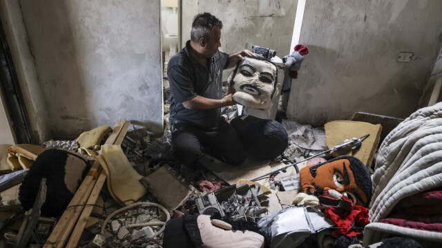 Nabil al-Khatib, artiste palestinien et fondateur de Beit al-Fann (la maison de l'art) dans la ville de Gaza, tente de récupérer quelques marionnettes de son studio, endommagé lors d'un récent bombardement israélien, le 29 mai 2021.