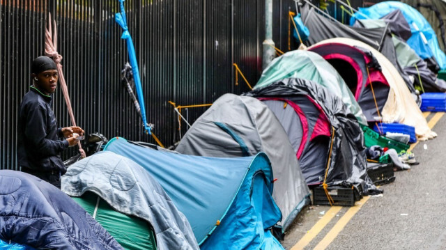 Un homme se tient parmi les tentes d'un camp de réfugiés improvisé devant l'Office de protection internationale du gouvernement irlandais, dans le centre ville de Dublin, le 12 juin 2023. 