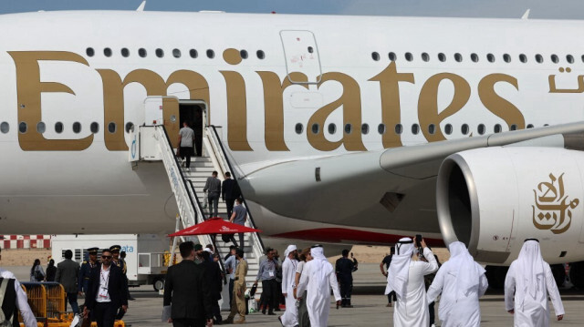 Des personnes visitant un avion d'Emirates sur le tarmac lors du salon aéronautique de Dubaï 2023 à l'aéroport international Dubai World Central - Al-Maktoum à Dubaï, le 13 novembre 2023.