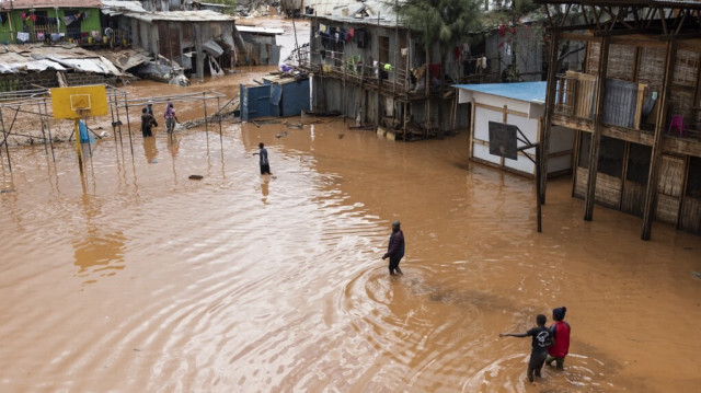 Des habitants du bidonville de Mathare traversent un champ d'école inondé à la suite de fortes pluies diluviennes dans la capitale, Nairobi, le 24 avril 2024. 