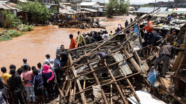 Des habitants du bidonville de Mathare se tiennent à côté de leurs maisons détruites près de la rivière Mathare, suite à de fortes pluies diluviennes dans la capitale, Nairobi, le 24 avril 2024. 