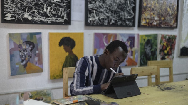 L'artiste Manzi Yvan Bryan, 19 ans, membre de l'équipe "Art for Memories", travaille sur le portrait d'une victime du génocide rwandais à Kigali le 2 avril 2024. 