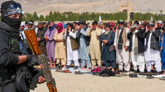 Un personnel de sécurité taliban se tient en garde alors que des fidèles musulmans afghans offrent les premières prières du vendredi midi du mois sacré islamique du Ramadan à la mosquée Guzargah à Hérat, le 15 mars 2024.
