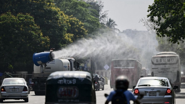 Un véhicule de la DNCC pulvérise de l'eau le long d'une route animée pour abaisser la température au milieu d'une vague de chaleur à Dacca, capitale du Bangladesh, le 27 avril 2024. 