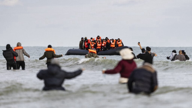 Des migrants se dirigent vers une embarcation de migrants qui tentent de traverser la Manche, sur la plage de Gravelines, près de Dunkerque, dans le nord de la France, le 26 avril 2024.