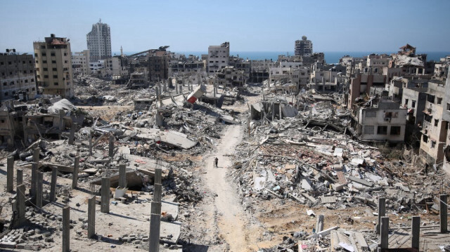 Un homme pousse un vélo alors qu'il marche au milieu des décombres d'un bâtiment dans la zone dévastée autour de l'hôpital Al-Shifa de Gaza, le 3 avril 2024.