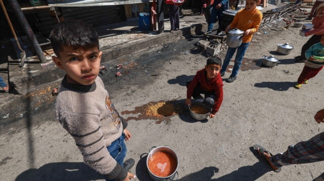 Des enfants palestiniens reçoivent des rations de nourriture cuisinée dans le cadre d'une initiative de jeunes volontaires à Rafah, dans le sud de la bande de Gaza, le 5 mars 2024.