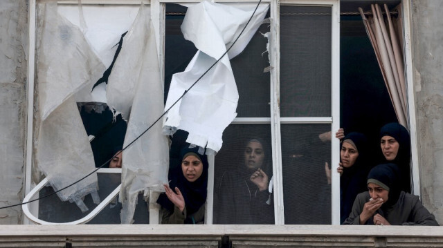 Des femmes palestiniennes pleurent en regardant depuis la fenêtre d'un appartement endommagé, le transfert des corps de parents tués dans un véhicule après un bombardement nocturne qui a visé une zone résidentielle à Rafah, dans le sud de la bande de Gaza, le 2 avril 2024.