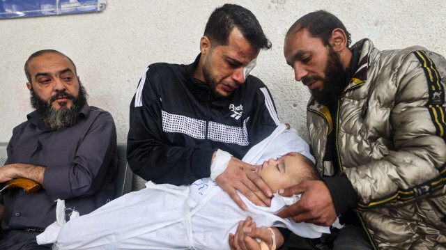 Ashraf, un père palestinien, tenant dans ses bras l'une de ses deux filles après qu'elles aient été tuées lors d'une frappe aérienne israélienne, le 4 avril 2024 à l'hôpital al-Najar de Rafah, dans le sud de la bande de Gaza, dans le cadre du conflit entre Israël et le groupe militant palestinien Hamas.