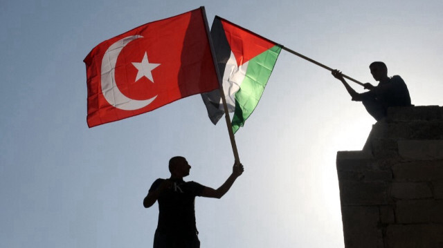 Des manifestants palestiniens brandissent leur drapeau national et le drapeau turc à Khan Younis, dans le sud de la bande de Gaza, le 14 octobre 2019.