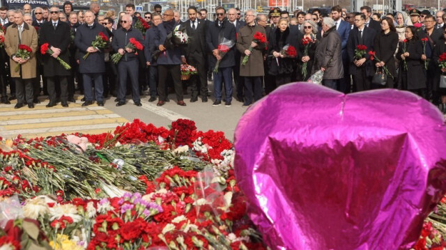 Des ambassadeurs et des représentants de missions diplomatiques accréditées en Russie sont au garde-à-vous alors qu'ils assistent à une cérémonie de dépôt de fleurs au mémorial à la mémoire des victimes de l'attaque terroriste au Crocus City Hall, une semaine après l'attaque à Krasnogorsk, près de Moscou, le 30 mars 2024.