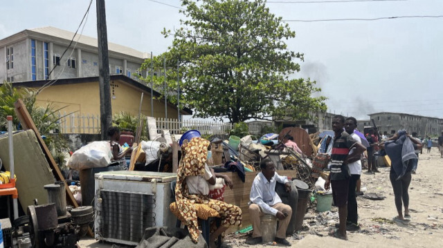 Des habitants sont assis près de leurs biens après la démolition d'une partie du quartier de Jakande à Lagos, le 14 mars 2024.