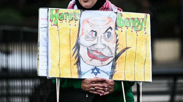Un partisan pro-palestinien tient une pancarte représentant une caricature du Premier ministre israélien Benjamin Netanyahu lors d'une marche nationale pour la Palestine dans le centre de Londres, le 17 février 2024.