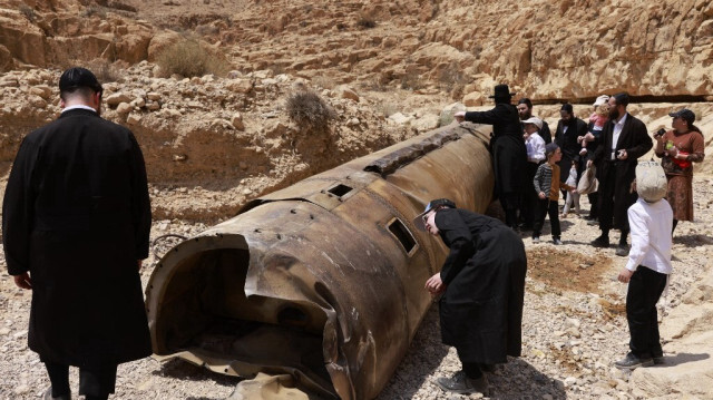 Des juifs ultra-orthodoxes autour des restes d'un des missiles balistiques tirés par l'Iran au début du mois et interceptés par Israël, qui a atterri dans une zone ouverte du désert du Néguev près de la ville d'Arad, le 30 avril 2024.