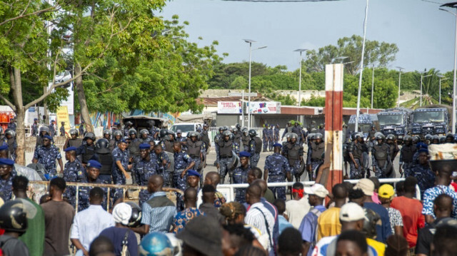 Des policiers bloquent une route alors que des manifestants défilent contre la cherté de la vie à Cotonou, le 27 avril 2024.  