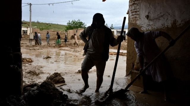 Des hommes afghans extraient la boue d'une maison suite à des inondations soudaines après de fortes pluies dans un village du district de Baghlan-e-Markazi dans la province de Baghlan, le 11 mai 2024.