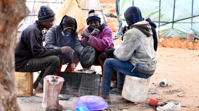 Des migrants d'Afrique subsaharienne se rassemblant autour d'un feu dans un camp à Jebeniana, dans le gouvernorat de Sfax, en Tunisie, le 24 avril 2024. Après que le président Kais Saied a déclaré dans un discours l'année dernière que les "hordes de migrants illégaux" représentaient une menace démographique pour la Tunisie, des violences anti-migrants ont éclaté et des centaines d'Africains subsahariens ont été chassés de leur travail et de leur maison.