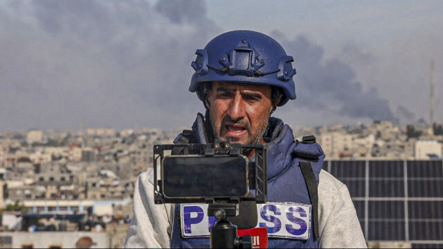 Un journaliste palestinien utilise son téléphone portable pour diffuser en direct à Rafah, dans le sud de la bande de Gaza, le 27 décembre 2023.