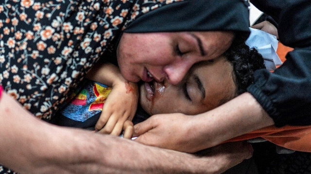 Une femme pleure le corps d'un enfant blessé lors d'un bombardement, dans le service de traumatologie de l'hôpital des martyrs d'Aqsa à Deir el-Balah, dans le centre de la bande de Gaza, le 11 mai 2024. 