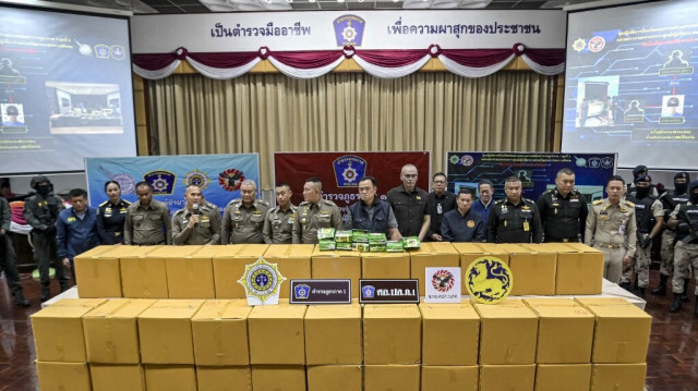 Le chef de la police nationale thaïlandaise par intérim Kittharath Punpetch (au centre à gauche) et le vice-premier ministre Anutin Charnvirakul (au centre à droite) se tiennent aux côtés d'autres fonctionnaires devant des boîtes de méthamphétamine en cristaux, lors d'une conférence de presse à Bangkok le 12 mai 2024.