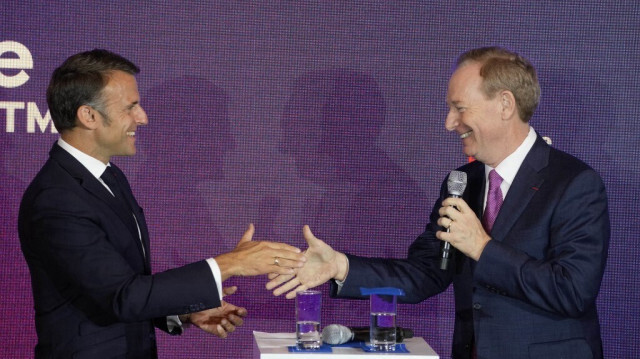 Le président français Emmanuel Macron serre la main du PDG de Microsoft, Brad Smith, au siège français de Microsoft à Issy-les-Moulineaux, au sud de Paris, le 13 mai 2024.