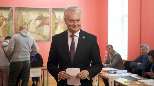 Le président lituanien Gitanas Nauseda s'apprête à déposer son bulletin de vote lors du premier tour de l'élection présidentielle à Vilnius, le 12 mai 2024.