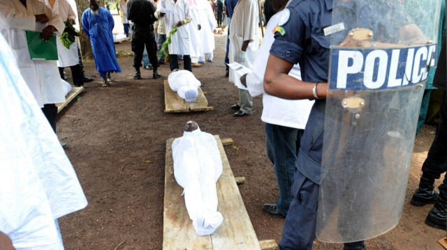 Un policier se tient le 2 octobre 2009 à côté des corps des personnes abattues par les forces de la junte guinéenne le 28 septembre 2009 devant la grande mosquée de Conakry. 