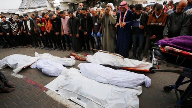 Des citoyens et des parents de Palestiniens, tués lors de l'attaque israélienne sur la maison appartenant à la famille Karajah, font la prière funéraire à  Gaza, le 14 mai 2024.