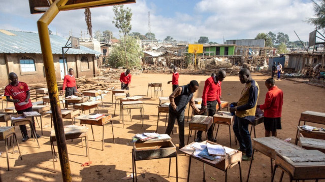 Des élèves de l'école secondaire Balozi sèchent des livres humides au soleil à l'extérieur de leur salle de classe qui a été touchée par les inondations dans le bidonville de Mathare à Nairobi, le 13 mai 2024.  