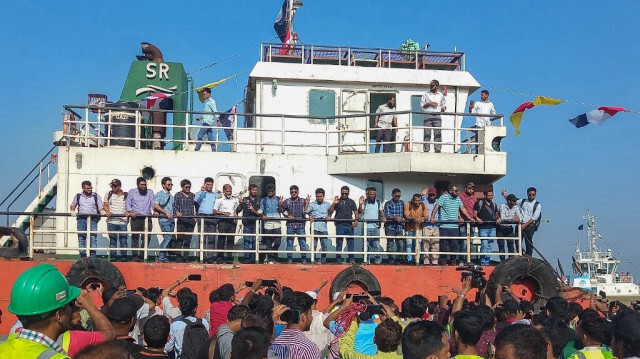 Des membres de la famille des captifs accueillent l'équipage (C) du navire MV Abdullah à leur arrivée au port de Chattogram à Chittagong, le 14 mai 2024, après leur libération par les pirates somaliens.