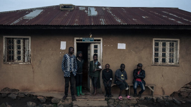 Un milicien pro-gouvernemental blessé (3e à gauche) se tient parmi d'autres patients devant un hôpital à Kanyabayonga, dans le sud du territoire de Lubero, dans la province du Nord-Kivu, dans l'est de la République démocratique du Congo, le 4 mai 2024. 