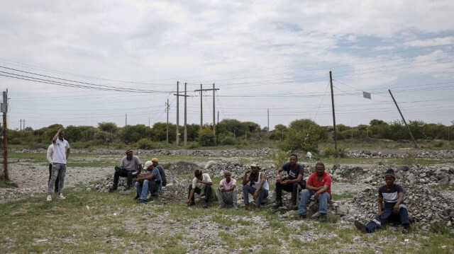 Des collègues de mineurs participant à une manifestation souterraine sont assis à proximité du puits nord de la mine de platine de Bafokeng Rasimone, près de Rustenburg, le 19 décembre 2023.