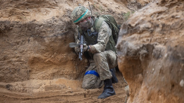 Un soldat ukrainien à l'assaut d'une tranchée lors d'un entraînement avec des soldats français, dans un complexe d'entraînement militaire situé en Pologne, le 4 avril 2024.