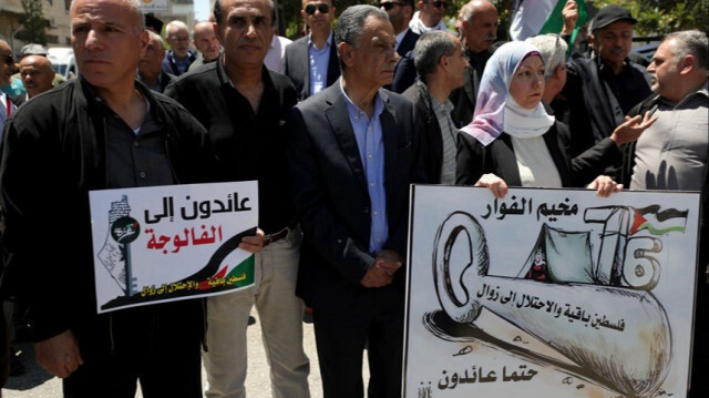 Des Palestiniens brandissant des banderoles défilent pour commémorer la Nakba à Hébron, en Palestine occupée, le 15 mai 2024.