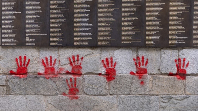 Des tags aux mains rouges sur le Mur des Justes devant le Mémorial de la Shoah à Paris, le 14 mai 2024.