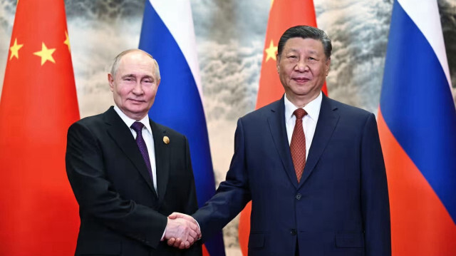 Президент России Владимир Путин (слева) и председатель КНР Си Цзиньпин пожимают друг другу руки перед началом переговоров в Пекине. 