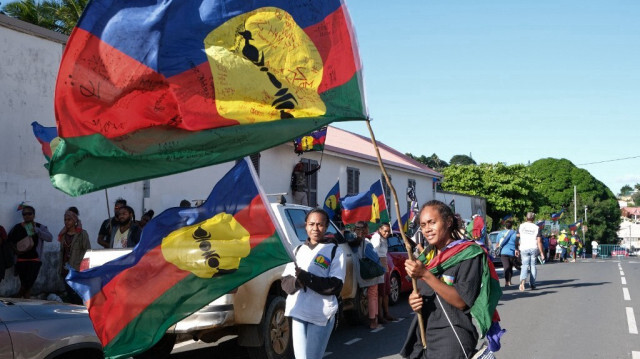 Autochotones de Nouvelle-Calédonie agitant le drapeau kanak du FLNKS, alors que les services de renseignement français accusent Ankara d'être à l'origine de l'insurrection.