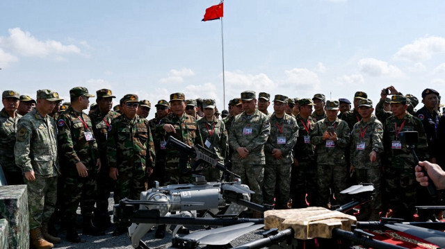 Le commandant en chef des Forces armées royales du Cambodge, Vong Pisen (au centre, à gauche), et le commandant du théâtre sud de l'Armée populaire de libération (APL), Gao Xiucheng (au centre, à droite), assistent à la démonstration d'un robot de combat équipé d'une mitrailleuse (C) lors de l'exercice Dragon Gold-2024 Cambodge-Chine dans une base de la police militaire de la province de Kampong Chhnang, le 16 mai 2024.