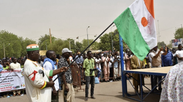 Un homme tient un drapeau du Niger alors que des manifestants se rassemblent lors d'une manifestation pour le départ immédiat des soldats de l'armée américaine déployés dans le nord du Niger à Niamey, le 13 avril 2024.