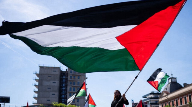 Un manifestant brandit le drapeau palestinien lors d'un rassemblement en soutien à Gaza sur la place Columbus à Vienne, en Autriche, le 4 mai 2024.