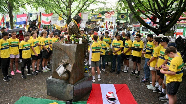 Les pilotes de Formule 1 rendent hommage au défunt pilote brésilien Ayrton Senna, au virage Tamburello sur le circuit d'Imola, en Italie, le 16 mai 2024, avant le Grand Prix d'Émilie-Romagne.  
