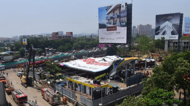 Des véhicules d'urgence sont garés sur le site un jour après l'effondrement d'un panneau publicitaire sur une station-service à la suite d'une tempête, à Mumbai le 14 mai 2024.