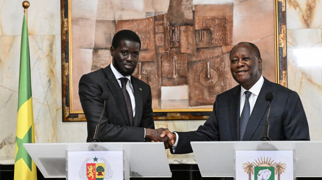 Le président sénégalais Bassirou Diomaye Faye (à gauche) et le président ivoirien Alassane Ouattara (à droite) se serrant la main lors d'une conférence de presse au palais présidentiel d'Abidjan, le 7 mai 2024, dans le cadre de la visite du président sénégalais en Côte d'Ivoire.
