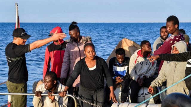 Un membre de la Garde nationale tunisienne dirige les migrants d'Afrique subsaharienne qui ont été secourus en mer à environ 50 milles nautiques en Méditerranée au large de la ville de Sfax, au centre de la Tunisie, le 4 octobre 2022.
