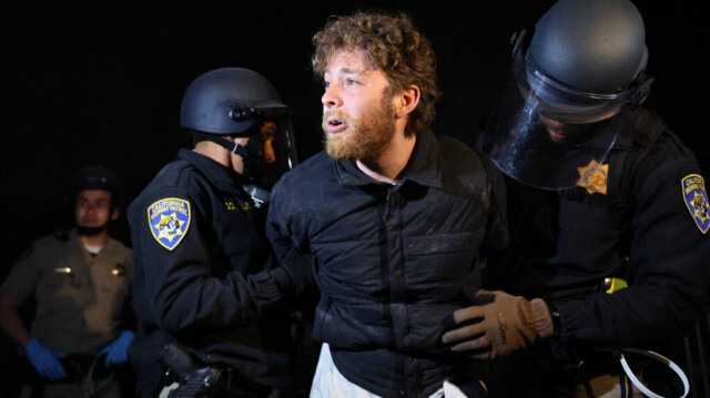 Des policiers de La California Highway Patrol (Patrouille d’autoroutes de Californie) arrêtent violemment un manifestant, déclarant être un étudiant juif de l'USC, lors de l'évacuation d'un campement pro-palestinien sur le campus de l'université de Californie à Los Angeles (UCLA), le 2 mai 2024.