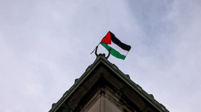 Un étudiant brandit un drapeau palestinien depuis le toit du Hamilton Hall lors d'une manifestation sur le campus de l'université de Columbia, à New York, le 30 avril 2024.