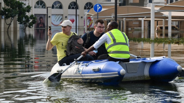 Un membre du personnel transporte des clients sur un bateau gonflable jusqu'à l'entrée d'un hôtel submergé par les eaux de crue à Dubaï, le 22 avril 2024.
