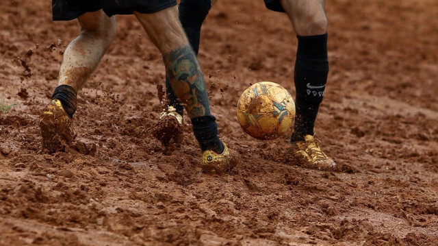 Des habitants jouent au football sur un terrain de sable à Sao Paulo, Brésil, le 17 février 2024.